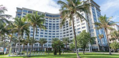 Sonesta Fort Lauderdale Beach’s exterior has extensive greenery, including numerous palm trees.