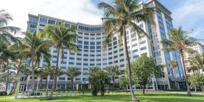 Sonesta Fort Lauderdale Beach’s exterior has extensive greenery, including numerous palm trees.