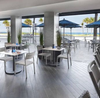 Sonesta Fort Lauderdale Beach’s Steelpan Restaurant serves up Caribbean-American fusion fare, with small tables, a hard floor and ocean views.