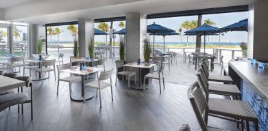 Sonesta Fort Lauderdale Beach’s Steelpan Restaurant serves up Caribbean-American fusion fare, with small tables, a hard floor and ocean views.