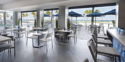 Sonesta Fort Lauderdale Beach’s Steelpan Restaurant serves up Caribbean-American fusion fare, with small tables, a hard floor and ocean views.