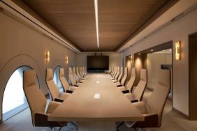 Meeting room in The Clift Royal Sonesta, featuring long table with seating for over a dozen attendees, cozy atmosphere, and large, wall-mounted TV.