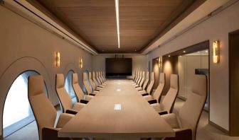 Meeting room in The Clift Royal Sonesta, featuring long table with seating for over a dozen attendees, cozy atmosphere, and large, wall-mounted TV.