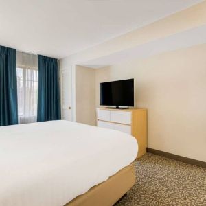 Double bed guest room in Sonesta ES Suites Charlotte Arrowood, including window and television.