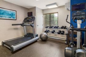 Sonesta ES Suites Charlotte Arrowood’s fitness center is equipped with rows of free weights and various exercise machines.