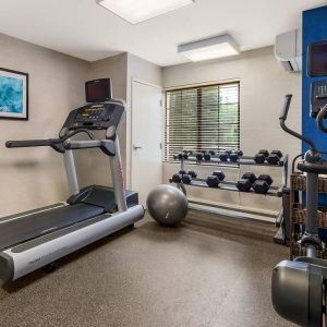 Sonesta ES Suites Charlotte Arrowood’s fitness center is equipped with rows of free weights and various exercise machines.