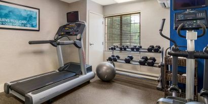 Sonesta ES Suites Charlotte Arrowood’s fitness center is equipped with rows of free weights and various exercise machines.