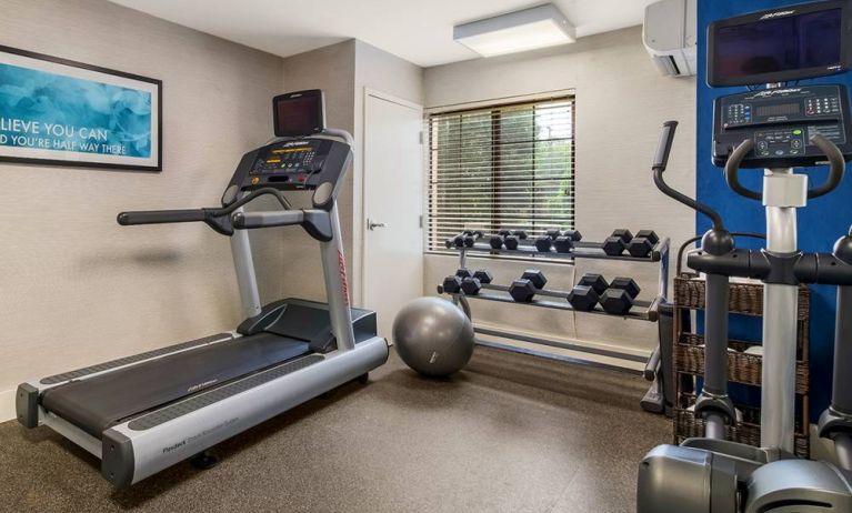 Sonesta ES Suites Charlotte Arrowood’s fitness center is equipped with rows of free weights and various exercise machines.