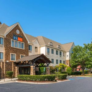 The hotel’s exterior has a pleasant abundance of greenery, including numerous trees, a covered entrance, and parking spaces.