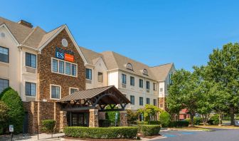 The hotel’s exterior has a pleasant abundance of greenery, including numerous trees, a covered entrance, and parking spaces.