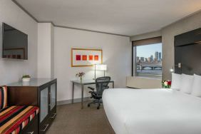 Royal Sonesta Boston double bed guest room, including workspace desk and chair, plus television.