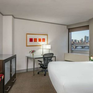 Royal Sonesta Boston double bed guest room, including workspace desk and chair, plus television.