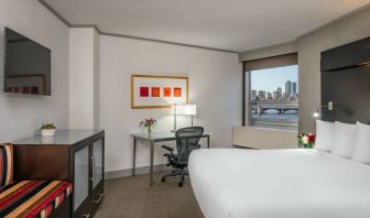 Royal Sonesta Boston double bed guest room, including workspace desk and chair, plus television.