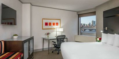 Royal Sonesta Boston double bed guest room, including workspace desk and chair, plus television.