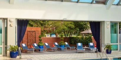 The indoor pool at Royal Sonesta Boston has plenty of natural light, with sun loungers and potted plants by the side.