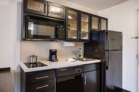 Sonesta Simply Suites Chicago Waukegan guest room kitchen, including sink, microwave, oven and hob, and fridge-freezer.