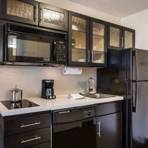 Sonesta Simply Suites Chicago Waukegan guest room kitchen, including sink, microwave, oven and hob, and fridge-freezer.