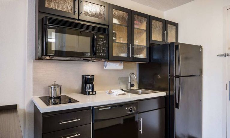 Sonesta Simply Suites Chicago Waukegan guest room kitchen, including sink, microwave, oven and hob, and fridge-freezer.