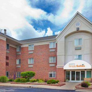 Sonesta Simply Suites Des Moines’ exterior has pleasant greenery, parking, and red brick architecture.