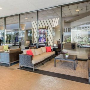 Sonesta Los Angeles Airport LAX’s lobby lounge features comfy sofa and armchair seating, and large coffee tables.