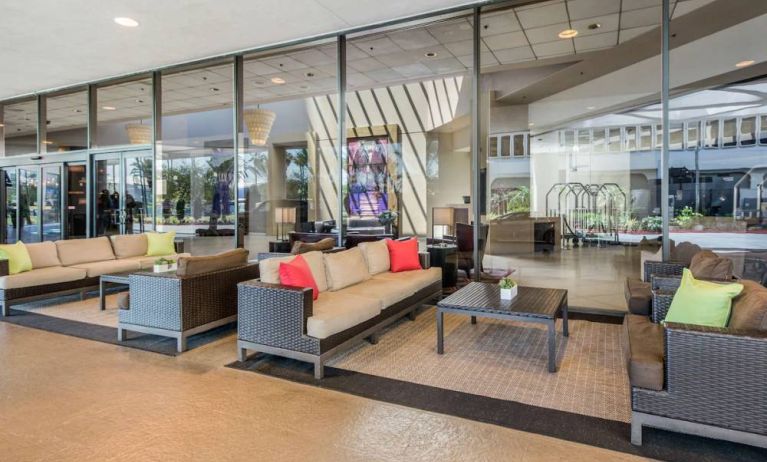 Sonesta Los Angeles Airport LAX’s lobby lounge features comfy sofa and armchair seating, and large coffee tables.