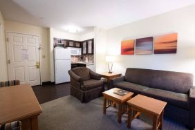 Lounge area in Sonesta ES Suites Austin The Domain Area guest room, furnished with sofa, armchair, and coffee tables.