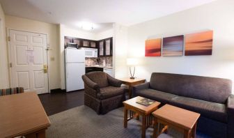 Lounge area in Sonesta ES Suites Austin The Domain Area guest room, furnished with sofa, armchair, and coffee tables.