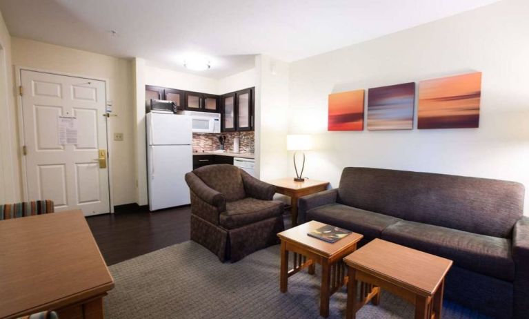 Lounge area in Sonesta ES Suites Austin The Domain Area guest room, furnished with sofa, armchair, and coffee tables.