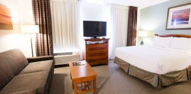 Double bed guest room in Sonesta ES Suites Austin The Domain Area, featuring sofa, coffee table, window, and TV.