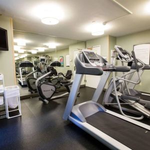 The fitness center at Sonesta ES Suites Austin The Domain Area includes a widescreen television, plenty of towels, and multiple exercise machines.