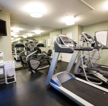 The fitness center at Sonesta ES Suites Austin The Domain Area includes a widescreen television, plenty of towels, and multiple exercise machines.