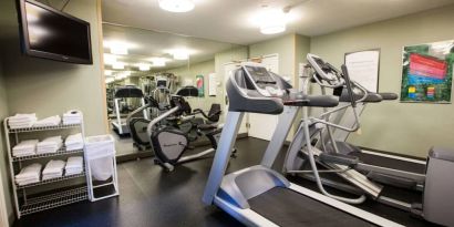 The fitness center at Sonesta ES Suites Austin The Domain Area includes a widescreen television, plenty of towels, and multiple exercise machines.