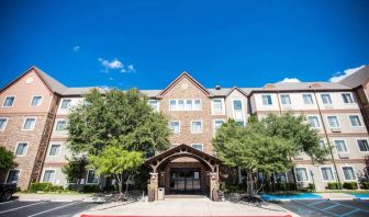 The hotel’s exterior has a covered entranceway flanked by trees, in addition to numerous parking spaces.