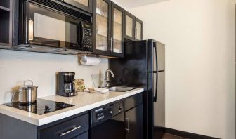 Fully equipped guest room kitchen in Sonesta Simply Suites Pittsburgh Airport, with fridge-freezer, microwave, oven, hob, and sink.