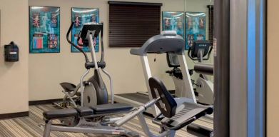 Sonesta Simply Suites Pittsburgh Airport’s fitness center is equipped with an assortment of exercise machines and a bench for those using weights.