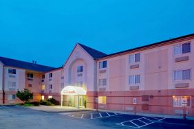 Sonesta Simply Suites Pittsburgh Airport’s exterior includes a covered entrance, pleasant greenery, and parking spaces.