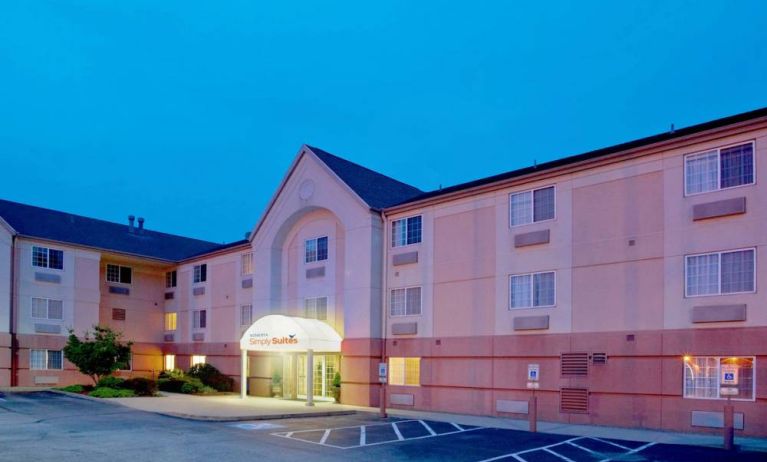 Sonesta Simply Suites Pittsburgh Airport’s exterior includes a covered entrance, pleasant greenery, and parking spaces.