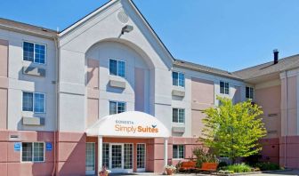 Sonesta Simply Suites Detroit Ann Arbor’s exterior features clear signage, and a pair of benches beside foliage including a tree.