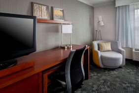 Sonesta Select Tinton Falls Eatontown guest room workspace, with desk, chair, and lamp, and TV.