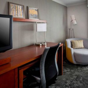 Sonesta Select Tinton Falls Eatontown guest room workspace, with desk, chair, and lamp, and TV.