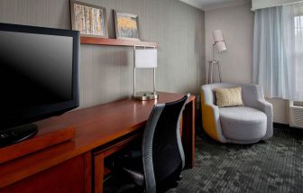 Sonesta Select Tinton Falls Eatontown guest room workspace, with desk, chair, and lamp, and TV.