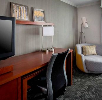 Sonesta Select Tinton Falls Eatontown guest room workspace, with desk, chair, and lamp, and TV.