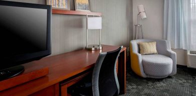 Sonesta Select Tinton Falls Eatontown guest room workspace, with desk, chair, and lamp, and TV.