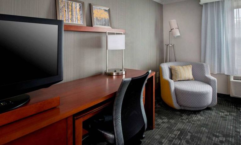 Sonesta Select Tinton Falls Eatontown guest room workspace, with desk, chair, and lamp, and TV.