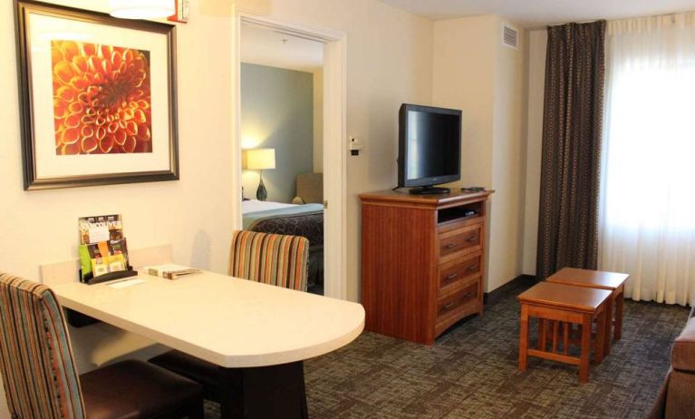 Sonesta ES Suites Portland Vancouver 41st Street guest room, furnished with double bed, desk and chairs, and a widescreen TV.