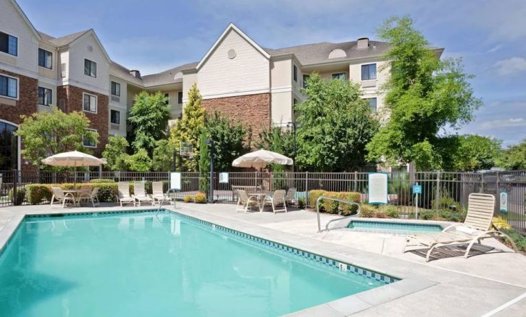 Sonesta ES Suites Portland Vancouver 41st Street’s outdoor pool has a nearby hot tub, with sun loungers, and shaded tables and chairs in the vicinity.