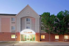 The hotel’s exterior has parking for guests on one side of the covered entrance, and trees to the other side.