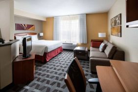 Sonesta Simply Suites Seattle Renton double bed guest room lounge, including sofa, TV, chair, and window.