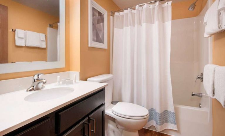 Sonesta Simply Suites Seattle Renton guest bathroom, furnished with bath and shower, lavatory, and mirror and sink.