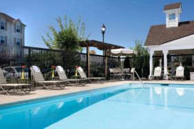 Sonesta Simply Suites Seattle Renton’s outdoor pool is fenced off and has both sun loungers and chairs by the side.